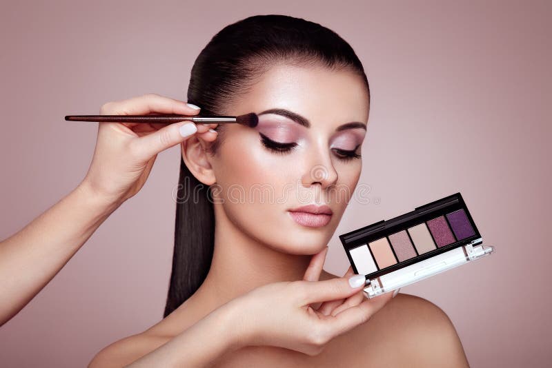 Makeup artist applies eye shadow