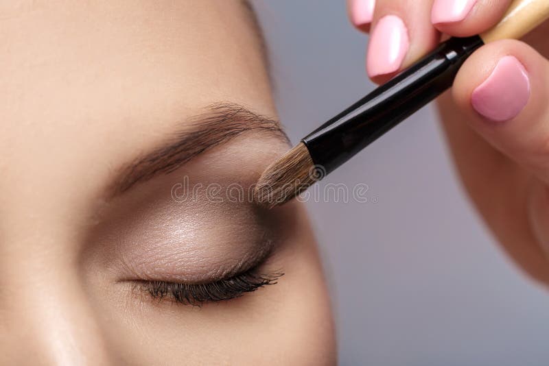 Makeup artist apply makeup brush for eyes. makeup for young girl. brown eye shadow. close up royalty free stock image Makeup artist apply makeup brush for eyes. makeup for young girl. brown eye shadow. close up royalty free stock image