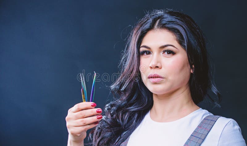 Makeup artist. Cosmetic tweezer. Girl makeup face hold tweezer for eyelash extension. Beauty shop concept. Makeup false stock images Makeup artist. Cosmetic tweezer. Girl makeup face hold tweezer for eyelash extension. Beauty shop concept. Makeup false stock images