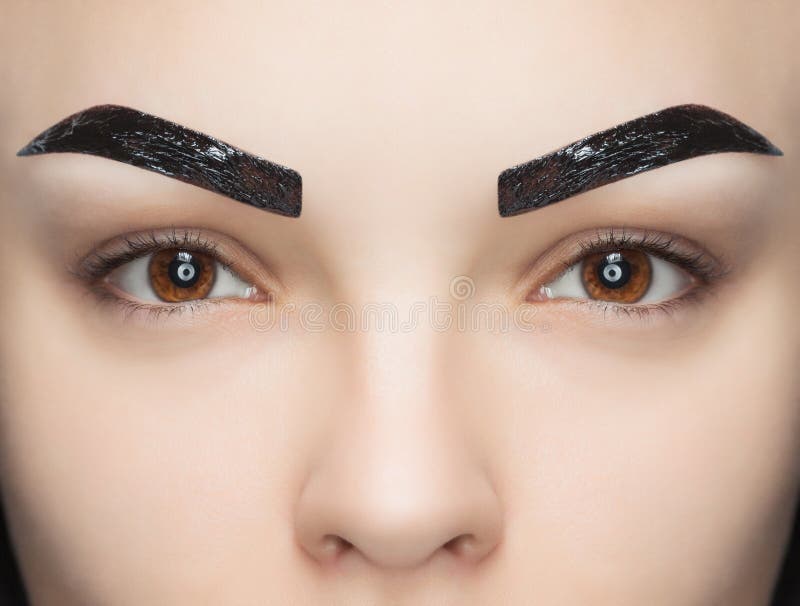 Makeup artysta stosuje farby hennę na brwiach w piękno salonie zdjęcia royalty free Makeup artysta stosuje farby hennę na brwiach w piękno salonie zdjęcia royalty free