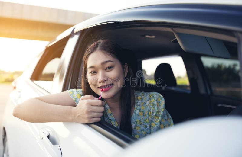Makeup in the Car, Young Woman Applying Makeup while Driving Stock