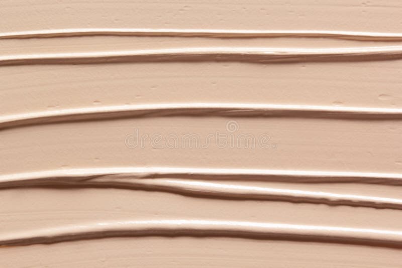 Makeup foundation creamy texture background. Skin tone concealer, color corrector strokes stock image