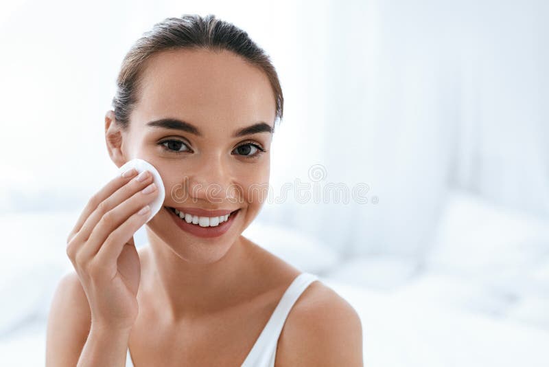 Makeup Remove. Girl Cleaning Face Skin With Cosmetic Pad stock photo Makeup Remove. Girl Cleaning Face Skin With Cosmetic Pad stock photo