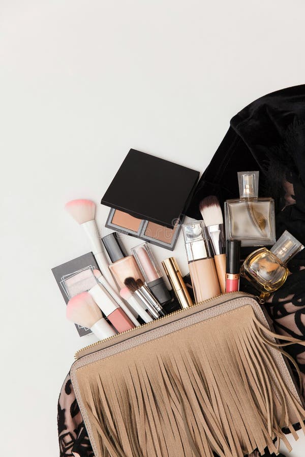 Makeup bag with cosmetic beauty products. Beauty and Fashion concept. Shoes, makeup products and handbag on white background. Cosmetic products flowing from Makeup bag on white background. Flat lay, top view.