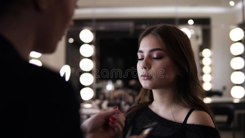 Makeupförlagen ökar ögonfrans, utgör konstnären som gör långa snärtar, kvinna i skönhetstudio, gör afton att utgöra