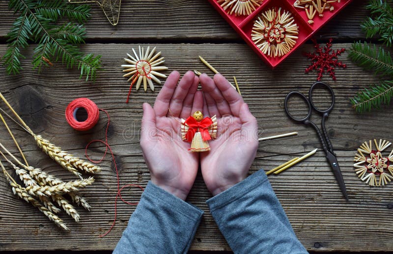 Making of handmade christmas toys from straw with your own hands. Children& x27;s DIY concept. Making xmas tree decoration