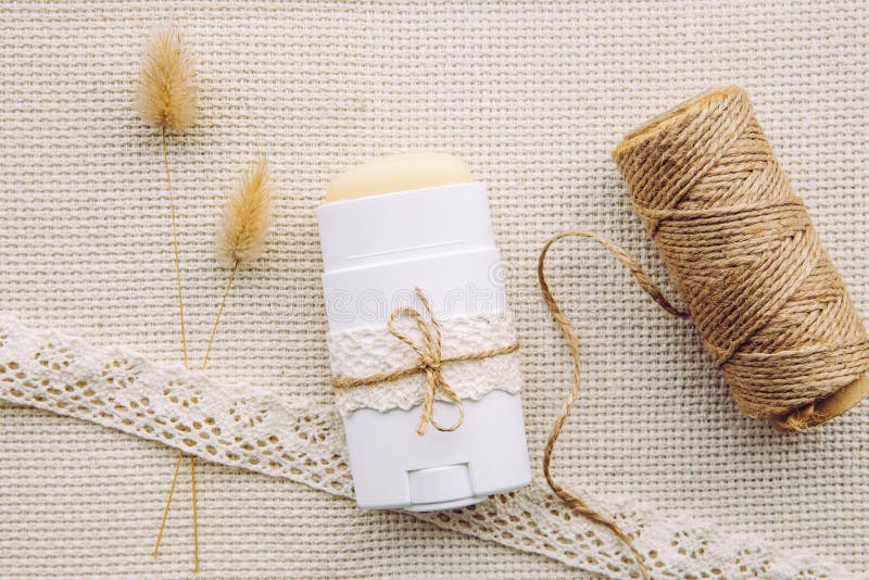 Making homemade deodorant stick with all natural ingredients concept. Flat lay view of refill container with natural antiperspirant on vintage background.