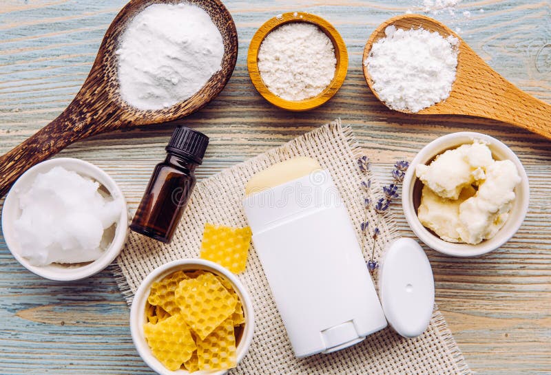 Making homemade deodorant stick with all natural ingredients concept. Blue wooden background. Ingredients: arrowroot powder, baking soda, beeswax, shea butter, essential oil, cornstarch, coconut oil.