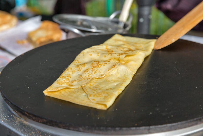Making pancake with filling on frying electric stove outdoor closeup