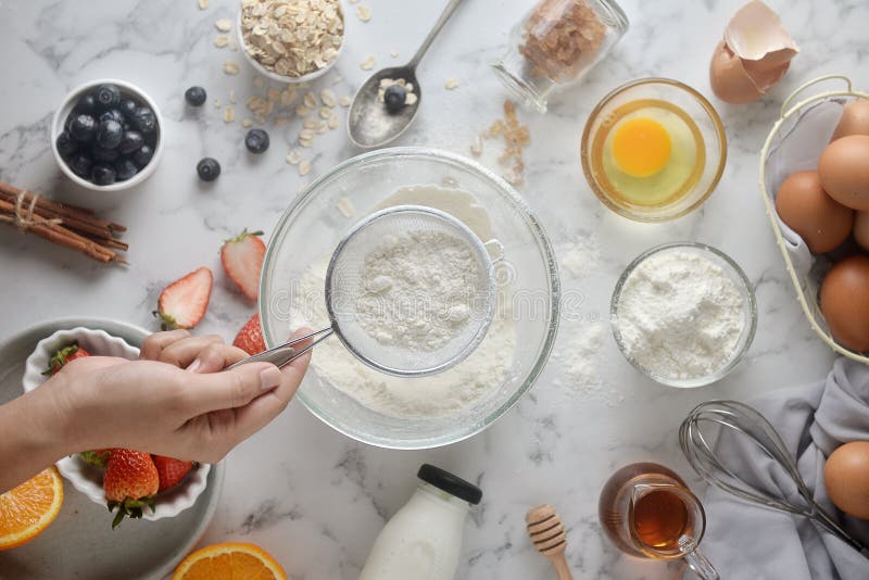 Making pancakes, cake, baking of baker hands pouring or sifting flour in bowl. Concept of Cooking ingredients and method on white stock photos Making pancakes, cake, baking of baker hands pouring or sifting flour in bowl. Concept of Cooking ingredients and method on white stock photos