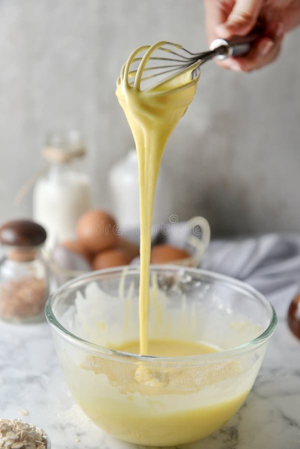 Making pancakes, cake, baking side view of baker hands pouring batter and whisking batter in bowl. Concept of Cooking ingredients stock photo Making pancakes, cake, baking side view of baker hands pouring batter and whisking batter in bowl. Concept of Cooking ingredients stock photo