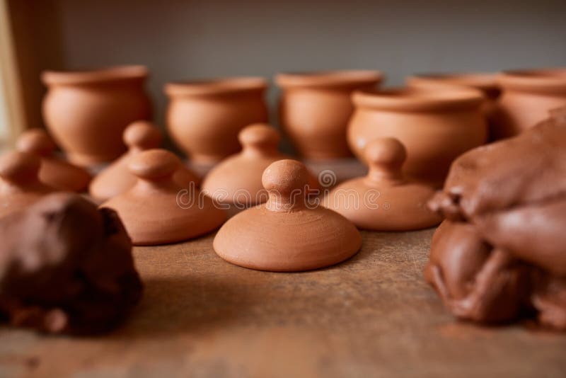 Making pottery on a potter`s wheel in the workshop, close-up, selective focus.