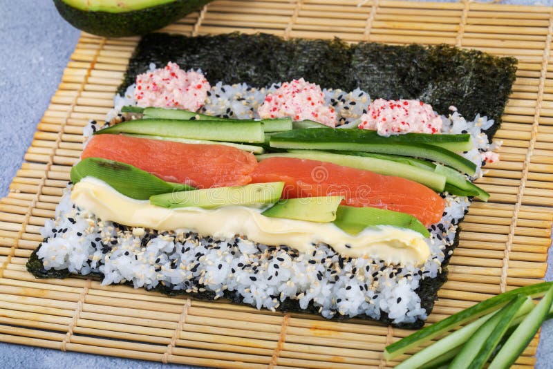 Making Rolled Sushi In A Bamboo Sushi Mat Stock Photo, Picture and