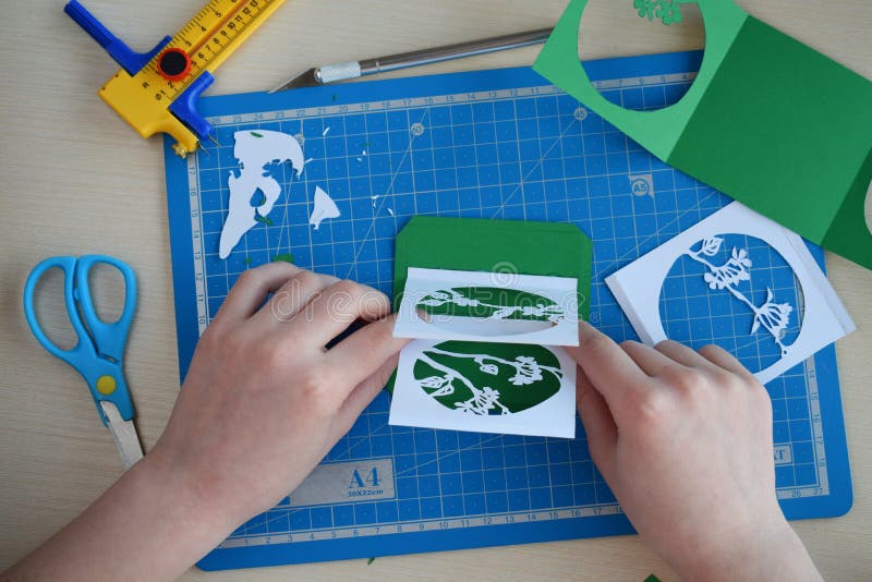 Making tunnelbook. 3D greeting card Spring. Artwork equipment and tools for paper cut - cutting knife, sharp box cutter, blue