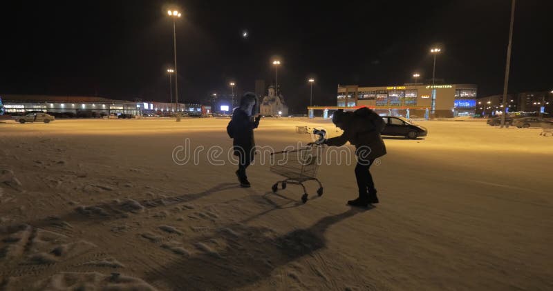 Making a video of woman walking near stores and using cellphone