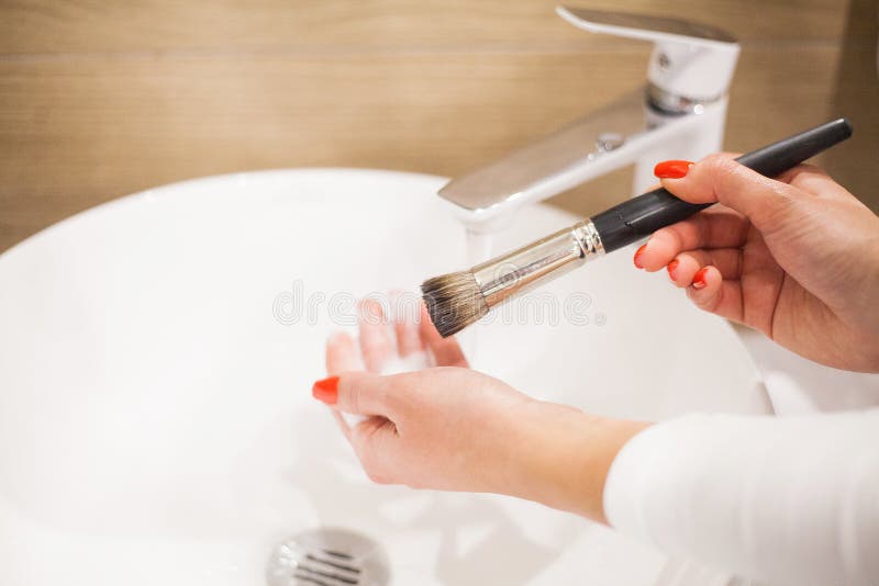 Makr up brush. Woman washing dirty makeup brush with soap and foam in the sink royalty free stock images Makr up brush. Woman washing dirty makeup brush with soap and foam in the sink royalty free stock images
