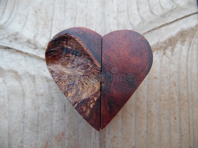 Macro photograph features a one of a kind, handcrafted wooden heart. Wood is in the background. Heart is crafted from Walnut burl. Concept can be love or craftsmanship. Macro photograph features a one of a kind, handcrafted wooden heart. Wood is in the background. Heart is crafted from Walnut burl. Concept can be love or craftsmanship.