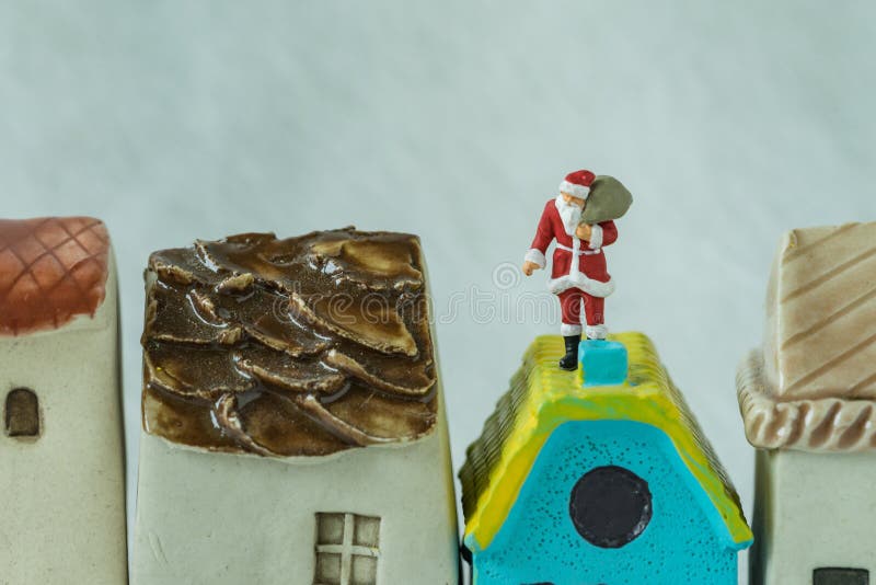 Makrosikt av miniatyrdiagramet Santa Claus anseende på takchim royaltyfri bild Makrosikt av miniatyrdiagramet Santa Claus anseende på takchim royaltyfri bild