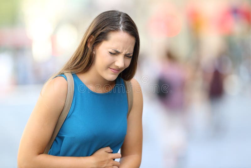 Mal de ventre de souffrance de femme extérieur dans la rue images libres de droits Mal de ventre de souffrance de femme extérieur dans la rue images libres de droits