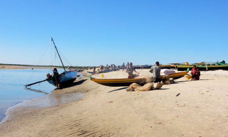 Malagasy κανό στην παραλία με τους εργαζόμενους ψαράδες στοκ εικόνα με δικαίωμα ελεύθερης χρήσης