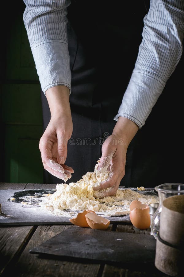 Malaxez la pâte par les mains femelles image stock Malaxez la pâte par les mains femelles image stock