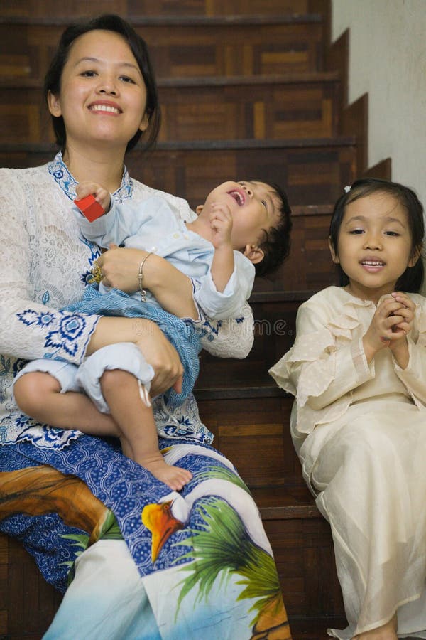 A malay m struggling to take a decent Aidilfitri picture with her kids stock photo. A malay m struggling to take a decent Aidilfitri picture with her kids stock photo