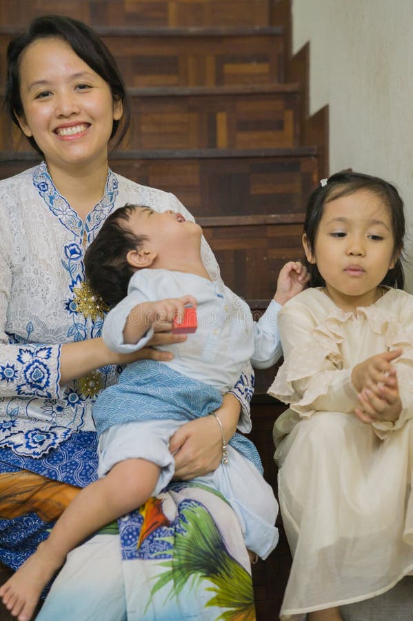 A malay m struggling to take a decent Aidilfitri picture with her kids stock photo. A malay m struggling to take a decent Aidilfitri picture with her kids stock photo