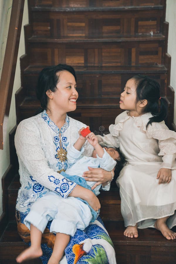 A malay m struggling to take a decent Aidilfitri picture with her kids stock photo. A malay m struggling to take a decent Aidilfitri picture with her kids stock photo