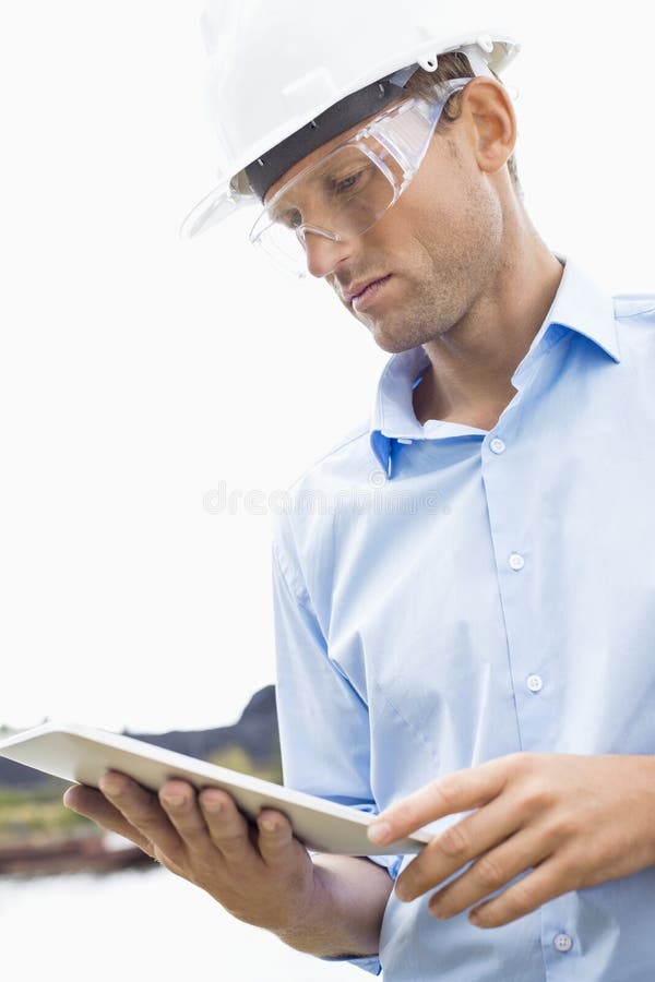 Male architect looking at tablet PC against sky royalty free stock photo