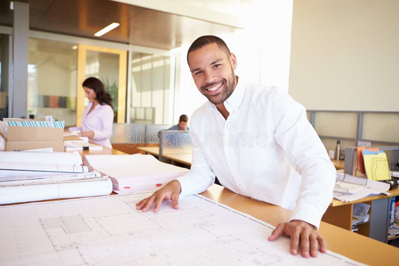 Male Architect Studying Plans In Office stock photography