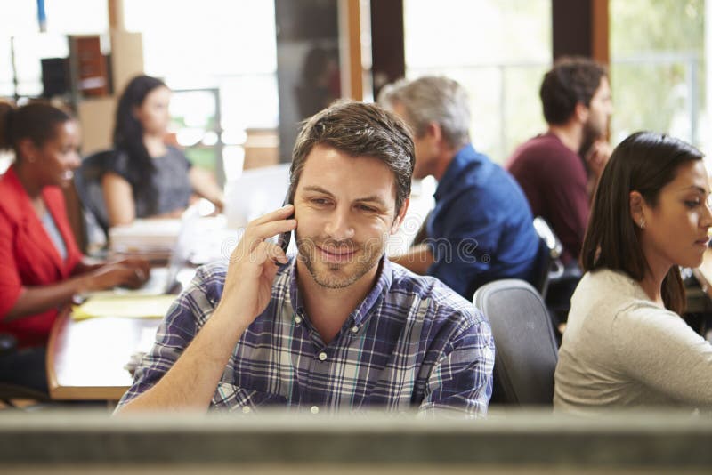 Male Architect Working At Desk With Meeting In Background royalty free stock images