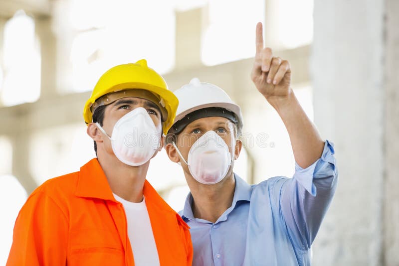 Male Architects Wearing Protective Mask while Working at Construction