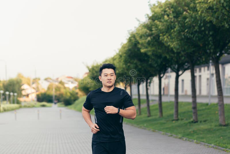 Male Asian Athlete on a Morning Run in the Park Near the Stadium Stock ...