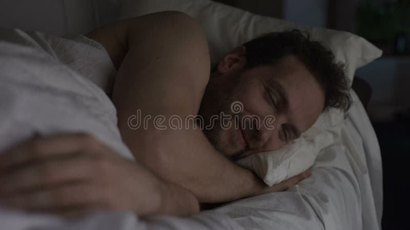 Male in bed smiling before falling asleep, pleasant thoughts positive experience