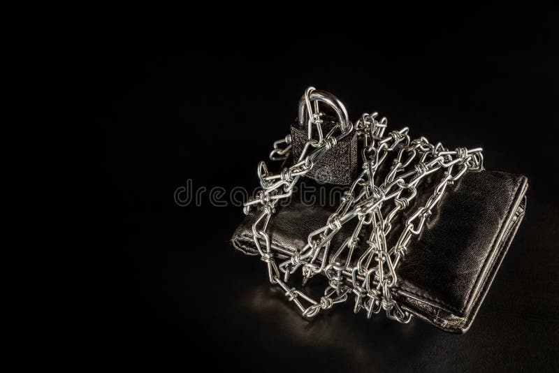 Male black chained purse is on the black background/table. There is the chain. Buy Nothing Day.