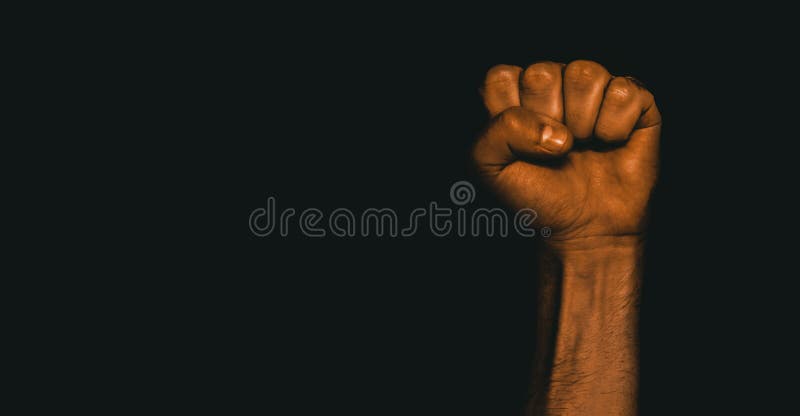 Male black fist on a black background. Aggressiveness, masculinity, the concept of challenge