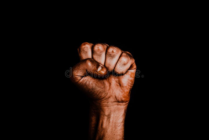 Male black fist on a black background. Aggressiveness, masculinity, the concept of challenge