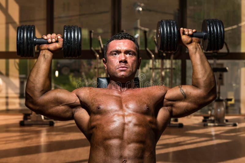 Male bodybuilder doing shoulder press whit dumbbell royalty free stock photos Male bodybuilder doing shoulder press whit dumbbell royalty free stock photos