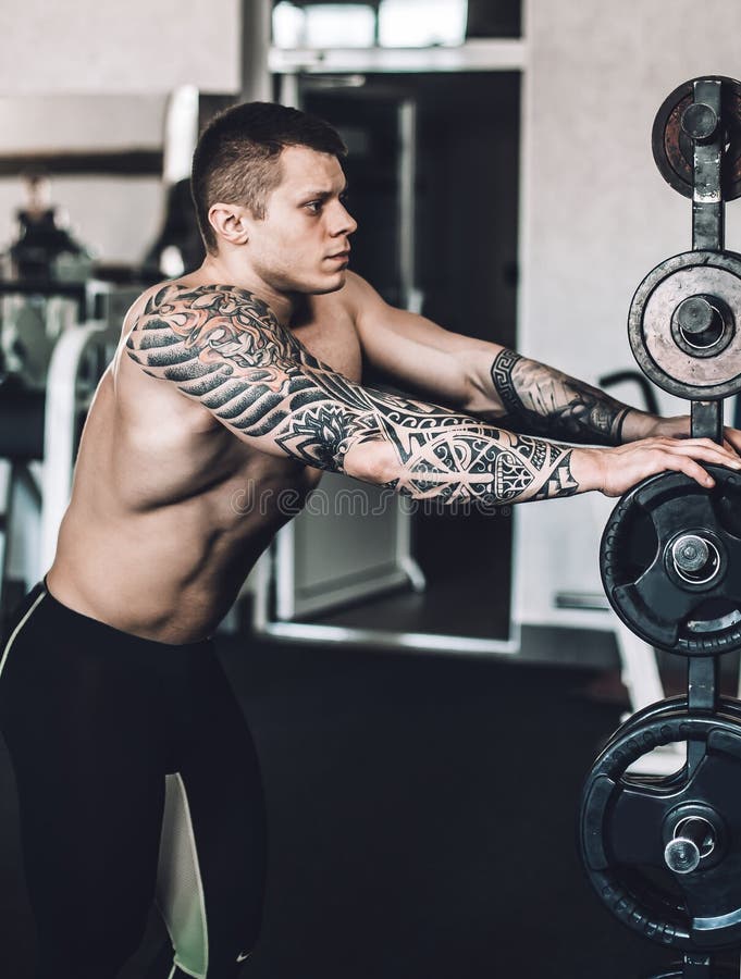 Male Bodybuilder with a Tattoo on His Arm Standing in the Gym Stock Photo - Image of lifter, body: 152826922 Male Bodybuilder with a Tattoo on His Arm Standing in the Gym Stock Photo - Image of lifter, body: 152826922
