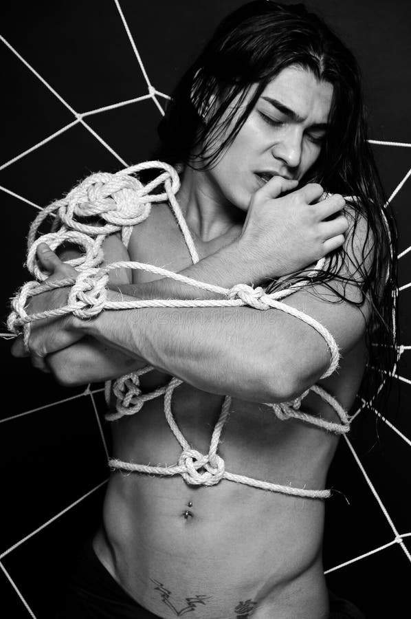 Muscled male model roped in traditional japanesse shibari royalty free stoc...