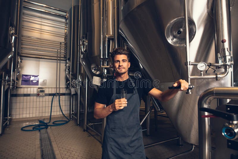 Male brewer standing by tank in brewery stock photography Male brewer standing by tank in brewery stock photography