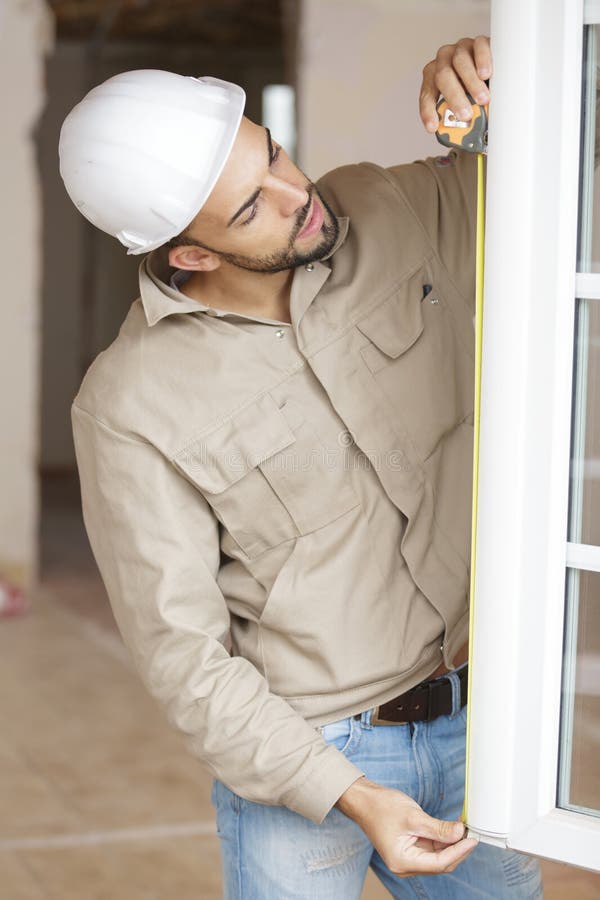 Male Builder Measuring Window Stock Photo Image of shutter, hurricane
