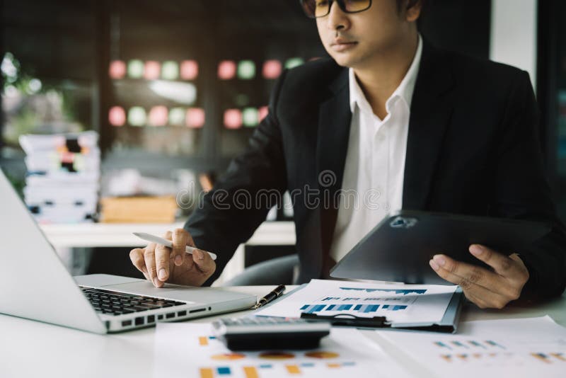 Male businessman and financial concepts about office work. Analysts discuss business with tablet and laptop as a tool.