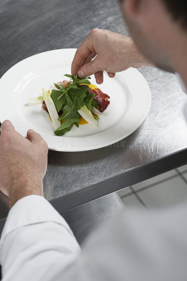 Male Chef Preparing Salad In Kitchen stock image