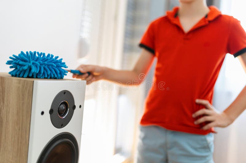 Male child cleaning the speakers. stock photo