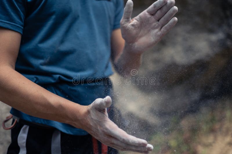 Male climber clapping hands together to remove the magnesium dust stock image