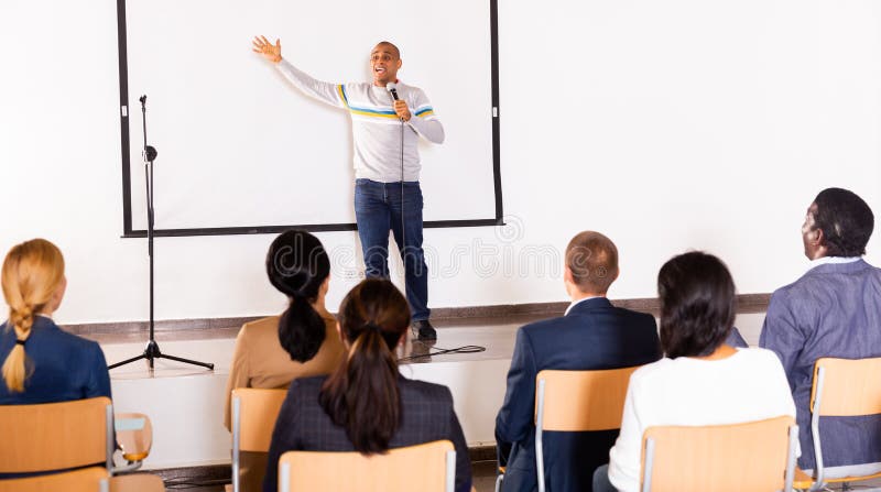 Male coach giving speech at conference hall royalty free stock photography