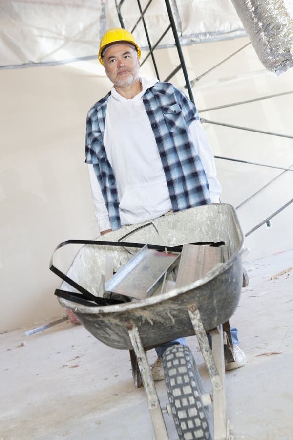 Male construction worker standing with a wheelbarrow stock photos