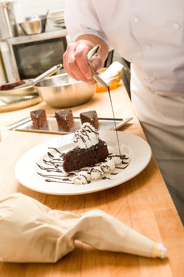 Male cook decorating slice of chocolate cake