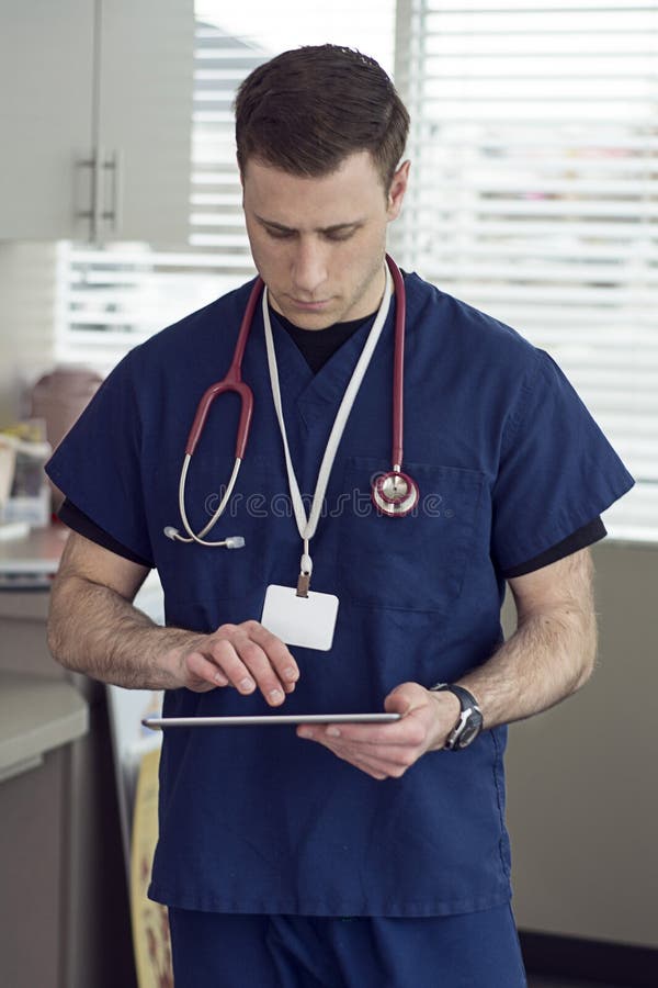 Male doctor looking at tablet for medical information royalty free stock image Male doctor looking at tablet for medical information royalty free stock image